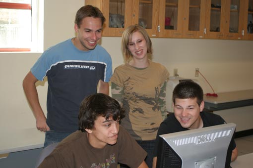 Jason Greenberg, Robert Kiffe, Michelle Martin, Tim Sanchez looking at a computer